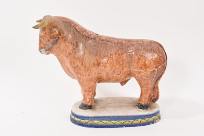 Lot 40 - Tin-glaze earthenware model of a bull, probably Dutch, polychrome painted on an oval base, 20.5cm high