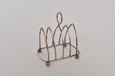 Lot 497 - Early George V silver four division toast rack, with loop carrying handle, on four ball feet