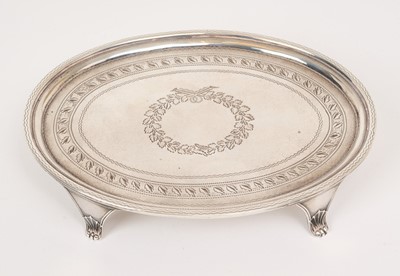 Lot 521 - George III silver teapot stand of oval form with bright cut engraved decoration