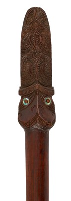 Lot 1168 - Māori taiaha club, typical form with carved Janus head, inset with abalone detail, with rich patination, 173cm long