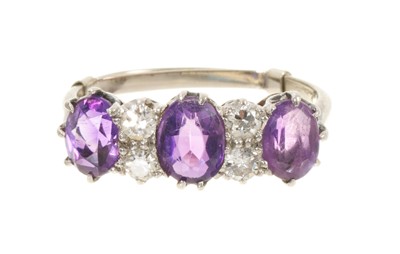 Lot 663 - Amethyst and diamond ring with three oval mixed cut amethysts interspaced by four old brilliant cut diamonds