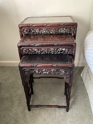 Lot 1697 - Nest of three Chinese carved hardwood occasional tables, with pierced frieze on faux bamboo supports, the largest 45cm wide