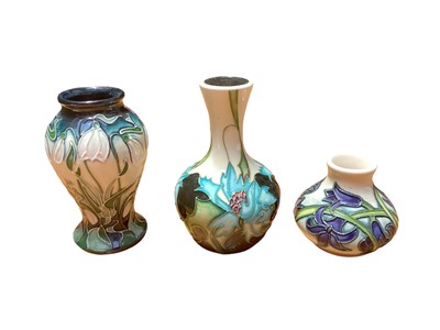 Lot 1150 - Three Moorcroft pottery vases including Sea Holly, dated 2006, 10.5cm high, Nivalis, dated 2002, 10cm high and Bluebells, dated 2004, 5.5cm high