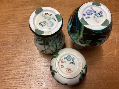 Lot 1150 - Three Moorcroft pottery vases including Sea Holly, dated 2006, 10.5cm high, Nivalis, dated 2002, 10cm high and Bluebells, dated 2004, 5.5cm high