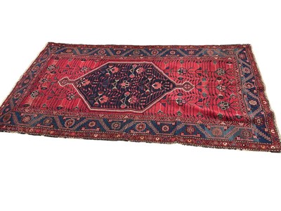 Lot 1757 - Persian rug, with central medallion on claret ground in geometric border, 230 x 120cm