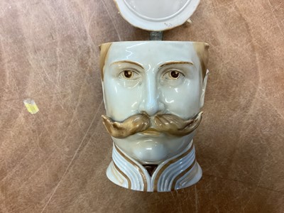 Lot 819 - Impressive Imperial German porcelain stein in the form of Kaiser Wilhelm II wearing a Garde du Corps helmet, the hinged cover with metal mount and ornate thumb piece with cross and laurel wreath...