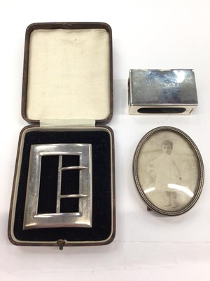 Lot 157 - Late Victorian silver buckle, Mappin & Webb silver matchbox holder and a small oval photograph frame (3)