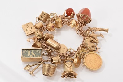 Lot 205 - 9ct gold charm bracelet with a collection of 9ct gold and yellow metal charms to include a gold half sovereign