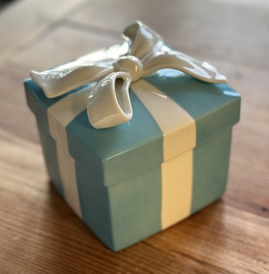 Lot 142 - Tiffany & Co. porcelain lidded box in the form of a turquoise wrapped present, 10cm sqaure