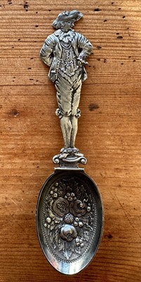 Lot 144 - Antique white metal spoon, the handle formed as a dandy, the bowl decorated with fruits and leaves in relief, 19.5cm long