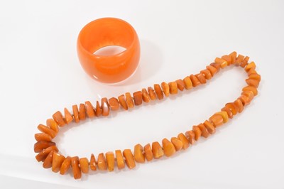 Lot 236 - Vintage amber bead necklace, 62cm long, and a simulated amber cuff bangle (2)