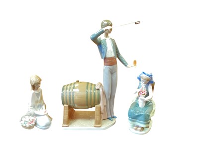 Lot 1251 - Three Lladro porcelain figures - Wine Taster and two girls with flowers (all boxed)