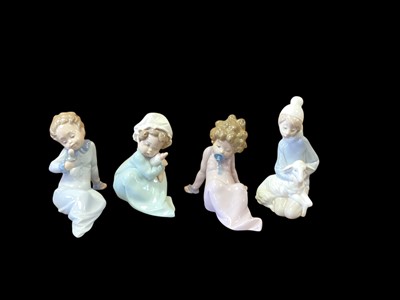 Lot 1255 - Four Lladro porcelain figures including three babies and a girl with a lamb, all boxed (one is the wrong box)