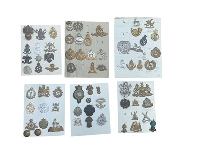 Lot 775 - Group of six boards mounted with a selection of British Military cap badges to include Essex Regiment and R.E.M.E (both wartime economy issue).