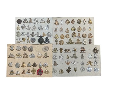 Lot 779 - Group of four boards mounted with a selection of British Military cap badges to include Machine Gun Corps, Royal Armoured Corps and Durham Light Infantry.