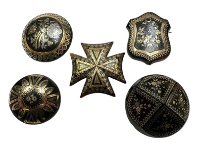 Lot 217 - Group of five 19th century tortoishell piqué work brooches, with floral decoration to include a Maltese cross brooch, 32-40mm diameter