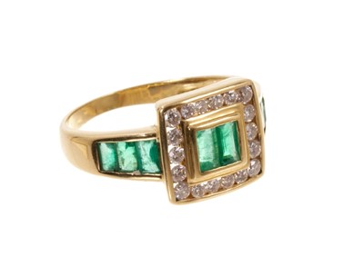 Lot 665 - Emerald and diamond ring with step cut emeralds and a square border of brilliant cut diamonds flanked by further emeralds to the shoulders on 18ct gold shank