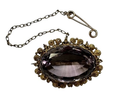 Lot 227 - 19th century amethyst brooch with oval facet cut stone within a canatille surround, measuring approximately 32mm x 25mm