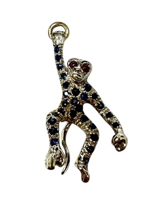 Lot 231 - Gold (18ct) novelty pendant in the form of a swinging monkey suspended from a gold ring with ruby eyes and pavé set sapphire body, 36mm