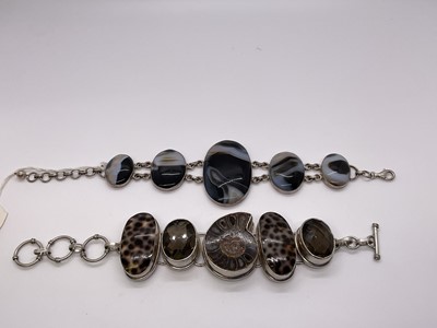 Lot 253 - Two silver bracelets, one with polished ammonite fossil, smokey quartz and shells, 21cm, the other bracelet with oval banded agates, 23cm (2)