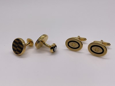 Lot 258 - A pair of Montblanc tigers eye and black onyx cufflinks with signature enamel Montblanc motif, together with a pair of Dunhill black enamel and engraved gilt metal cufflinks (2)