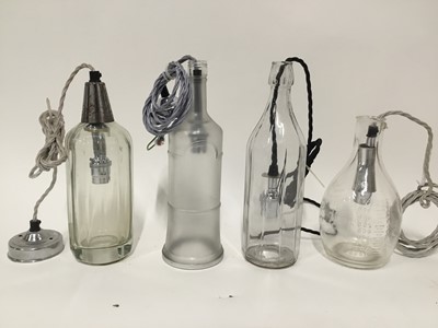 Lot 166 - Four glass bottle hanging lanterns, one a measuring jug, another a soda siphon, each with cord fittings