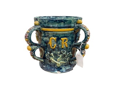 Lot 12 - Castle Hedingham Edward Bingham blue glazed pottery four handled jug / loving cup with applied floral decoration and 1650, the base marked No 22, E.W Bingham, 19cm high