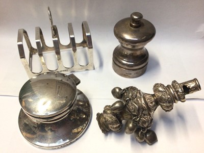 Lot 1023 - Group of silver items to include a silver toast rack, silver inkwell, silver pepper grinder and a Victorian white metal child's rattle, missing handle