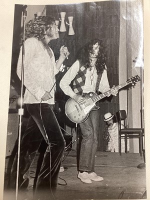 Lot 100 - Rare and historic black and white photograph of Robert Plant and Jimmy Page, Zacron is offstage in the background, image 24 x 16cm, in an album of photographs of Zacron and others including arti...