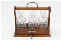 Lot 989 - Early 20th century oak tantalus of...