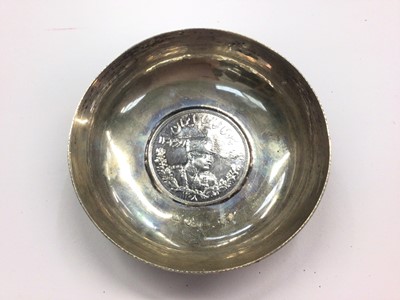 Lot 1035 - White metal foliate scroll engraved pin dish inset with Iran 5000 Dinar coin, 8cm diamater