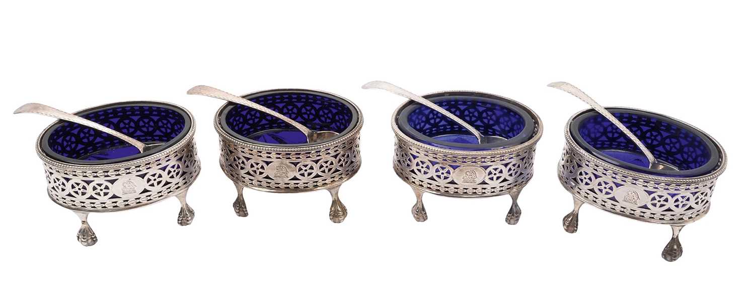 Lot 277 - Set of four Georgian oval salts on paw feet, with blue glass liners and spoons