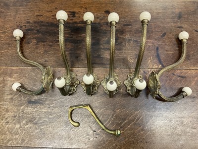 Lot 225 - Set of six large Victorian brass coat hooks with ceramic terminals, plus one other (7)