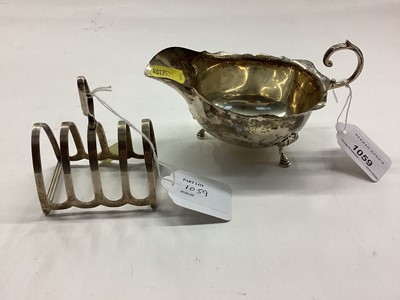 Lot 1059 - Silver sauce boat of helmet form together with a silver four division toast rack (2)