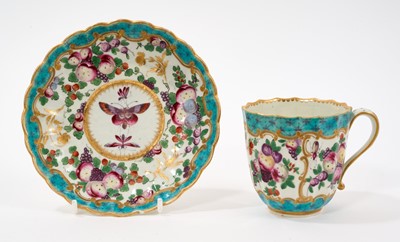 Lot 28 - An unusual Worcester fluted porcelain cup and saucer, circa 1770, painted in enamels with fruit and insects, with gilt and turquoise scroll borders, the saucer 13.5cm diameter