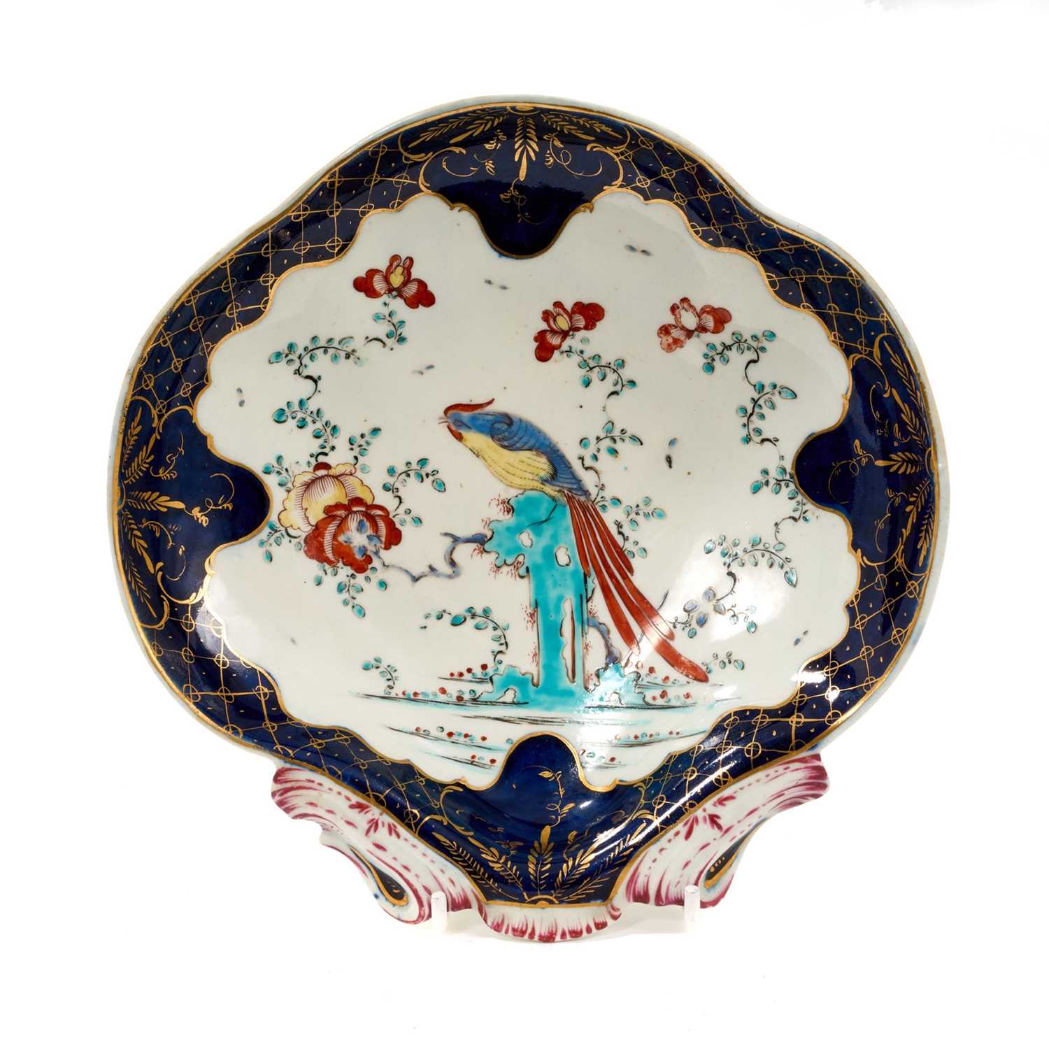 Lot 41 - A Worcester porcelain shell moulded dessert dish, circa 1770, decorated in enamels with the Sir Joshua Reynolds pattern, with gilt-patterned and wet blue border, 19cm wide
