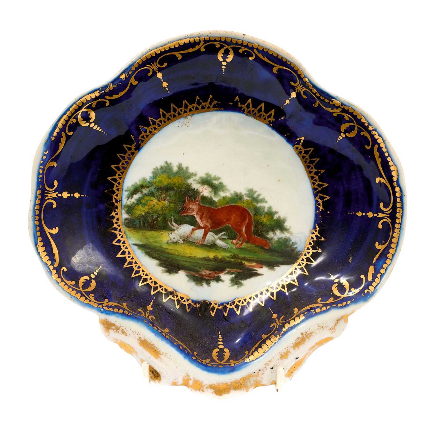 Lot 65 - Worcester Fable shell shaped dish, circa 1768, painted by Jefferyes Hamett O'Neale with The Fox and the Sheep, within gilt cartouche, gilt dentil rim, 20.75cm wide