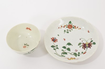 Lot 11 - A Worcester Hibiscus pattern tea bowl and saucer, circa 1758, decorated with scroll emblem, large honeysuckle flower, trailing vines and insects, the saucer 12cm diameter