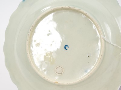 Lot 47 - An unusual Worcester scalloped plate, circa 1770, the centre enamelled with spotted fruit and two insects, with raised swag decoration outside, on wet blue ground, believed by John Sandon to hav...