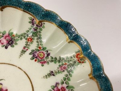 Lot 27 - A Worcester fluted tea bowl and saucer, circa 1775, polychrome painted with swags of flowers in Hop Trellis style, on turquoise scale ground, the saucer 13.5cm diameter, together with a Queen's...
