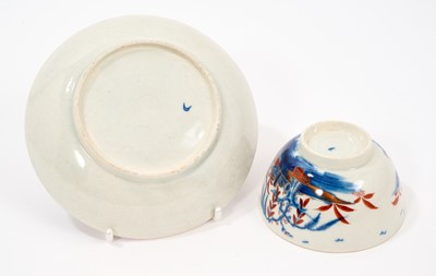 Lot 65 - A rare Worcester tea bowl and saucer, circa 1765-70, painted in the Candle Fence Pavilion pattern and clobbered at the factory, crescent marks, the saucer 12.5cm diameter