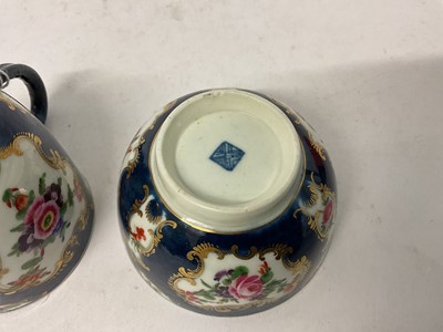 Lot 38 - A Worcester trio, circa 1760-70, comprising coffee cup, tea bowl and saucer, polychrome painted with floral sprays in gilt scrollwork panels, on a blue scale ground, square marks to bases