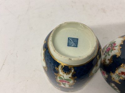 Lot 38 - A Worcester trio, circa 1760-70, comprising coffee cup, tea bowl and saucer, polychrome painted with floral sprays in gilt scrollwork panels, on a blue scale ground, square marks to bases