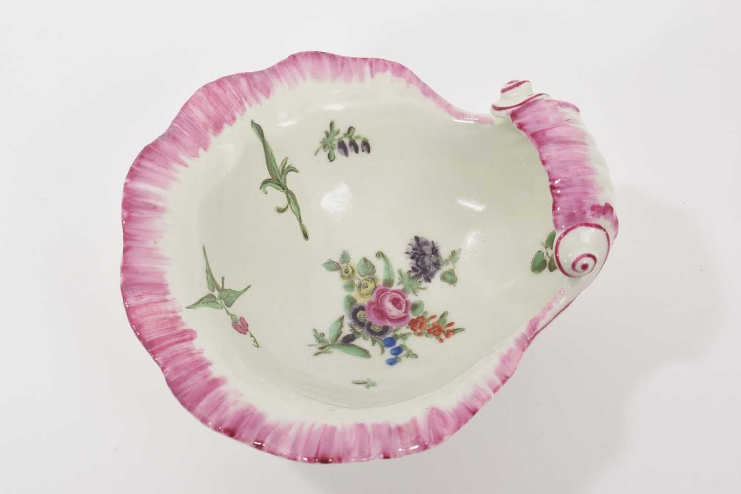 Lot 13 - A Worcester shell-shape sweetmeat dish, circa 1758, painted with a spray of flowers, scattered sprigs, within a puce border 12cm wide