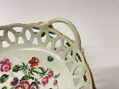 Lot 20 - A Worcester round basket, circa 1770, polychrome painted with flowers, the handles with flower and leaf terminals, the outside with applied florets picked out in puce and green, 17cm wide