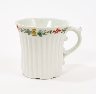 Lot 8 - An early Worcester coffee can, circa 1754-55, of elegant reeded form, with flared indented rim, bevelled base and scroll handle, the border painted with flowers in the famille verte style, 5.6cm...