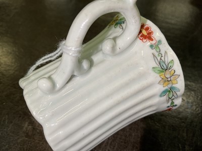 Lot 8 - An early Worcester coffee can, circa 1754-55, of elegant reeded form, with flared indented rim, bevelled base and scroll handle, the border painted with flowers in the famille verte style, 5.6cm...