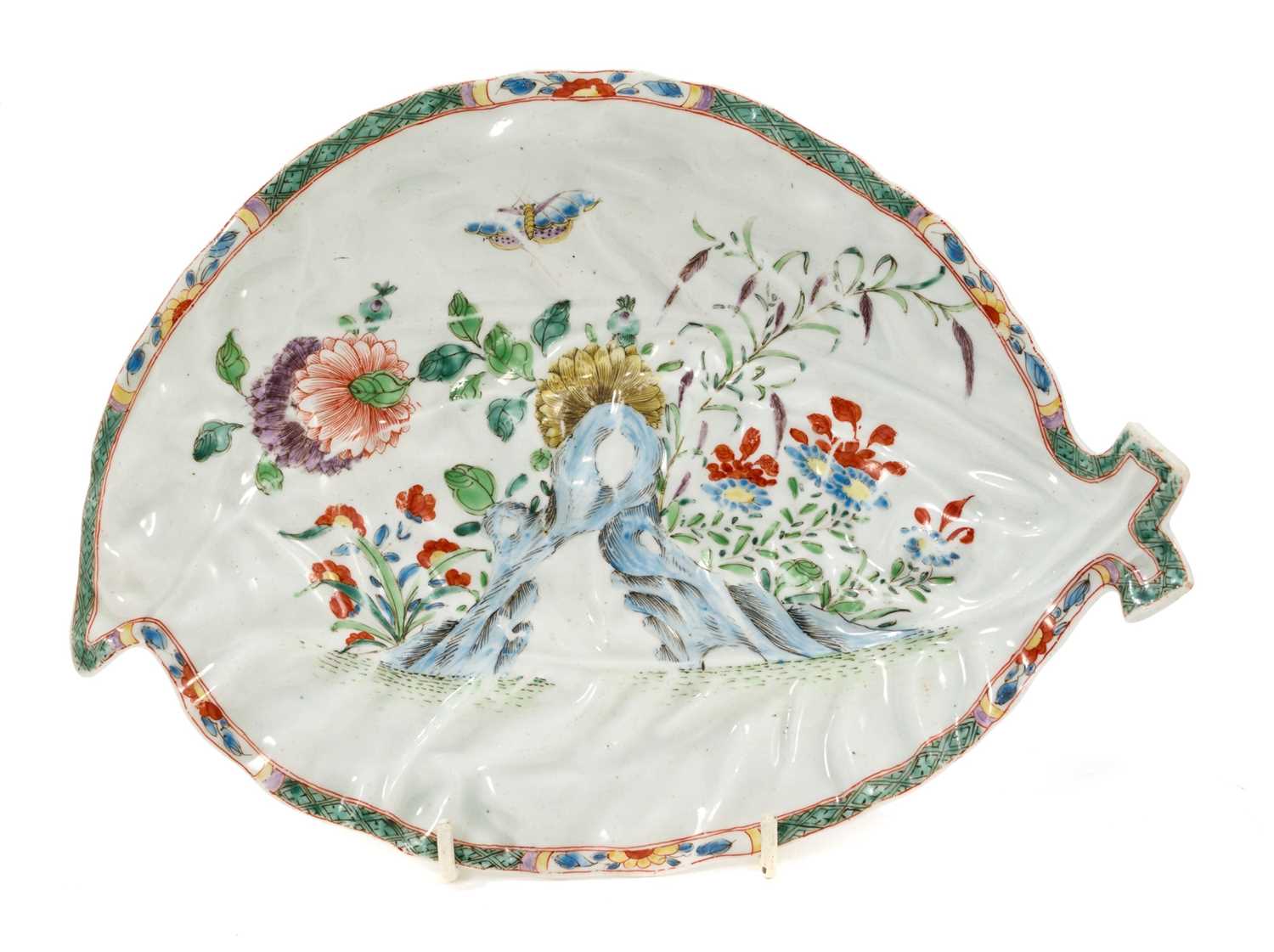 Lot 15 - A Worcester cabbage leaf dish, circa 1755-60, painted with flowers, rockwork and a moth, in the Chinese style with 'famille verte' enamels, the edge with floral panels on a diaper ground, 25.5cm...