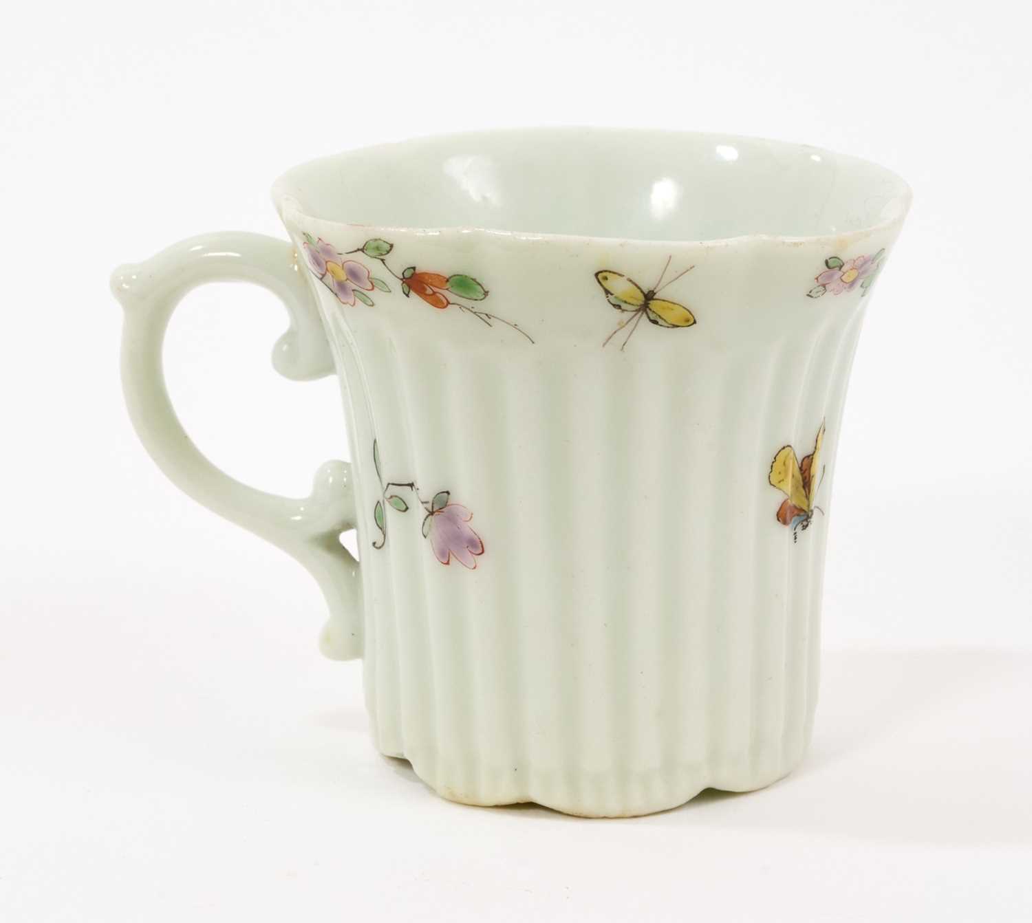 Lot 10 - An early Worcester coffee can, circa 1754-55, of elegant reeded form, with flared indented rim, bevelled base and scroll handle, painted with flowers and insects in the famille verte style, 5.5c...