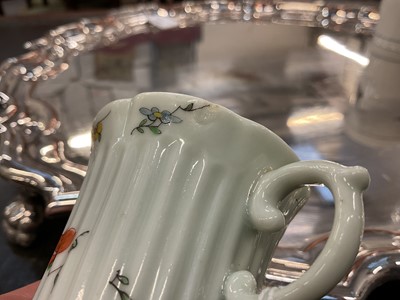Lot 10 - An early Worcester coffee can, circa 1754-55, of elegant reeded form, with flared indented rim, bevelled base and scroll handle, painted with flowers and insects in the famille verte style, 5.5c...